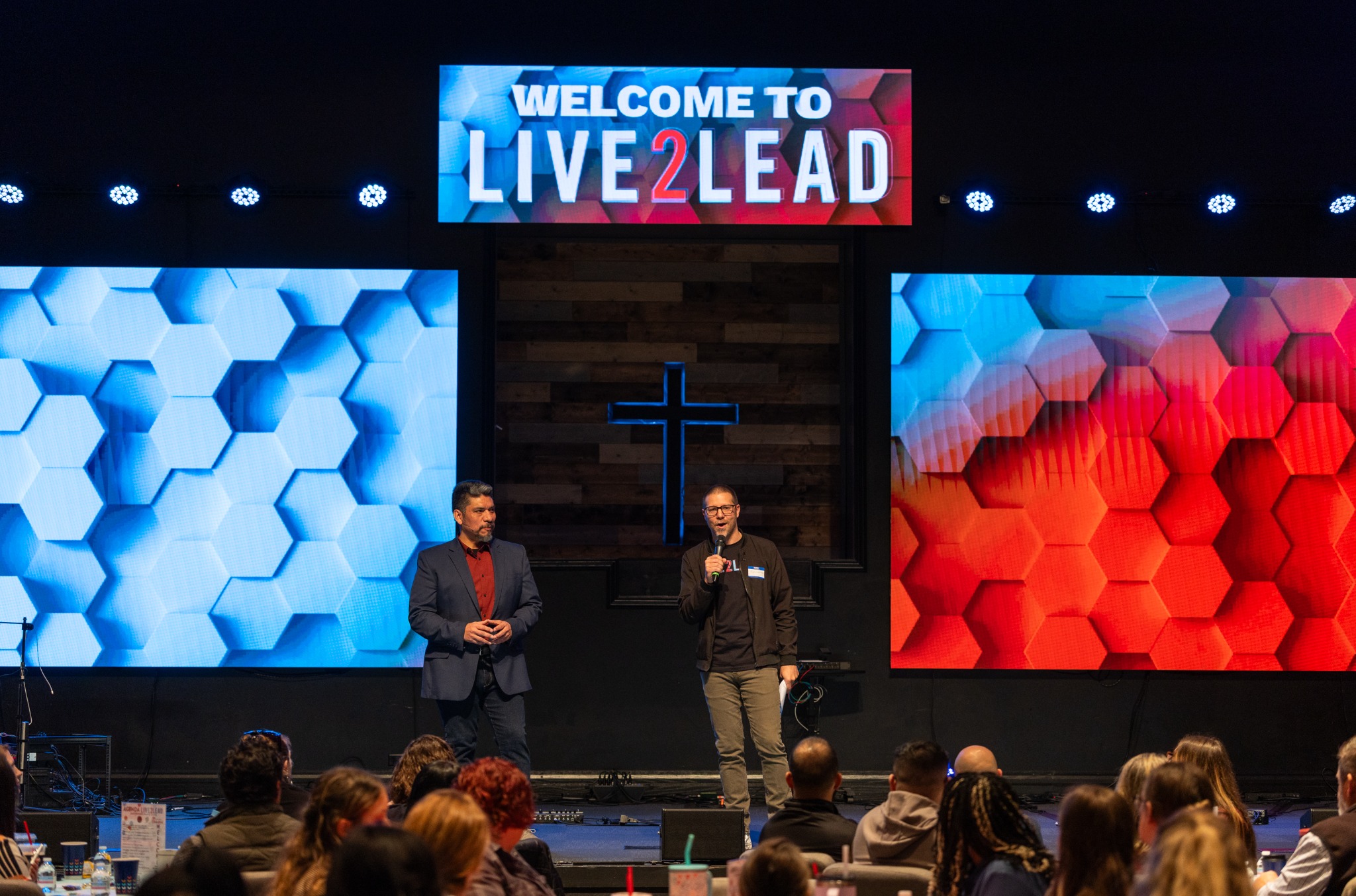 Heber Mena and a fellow presenter welcoming the audience on the Live2Lead stage