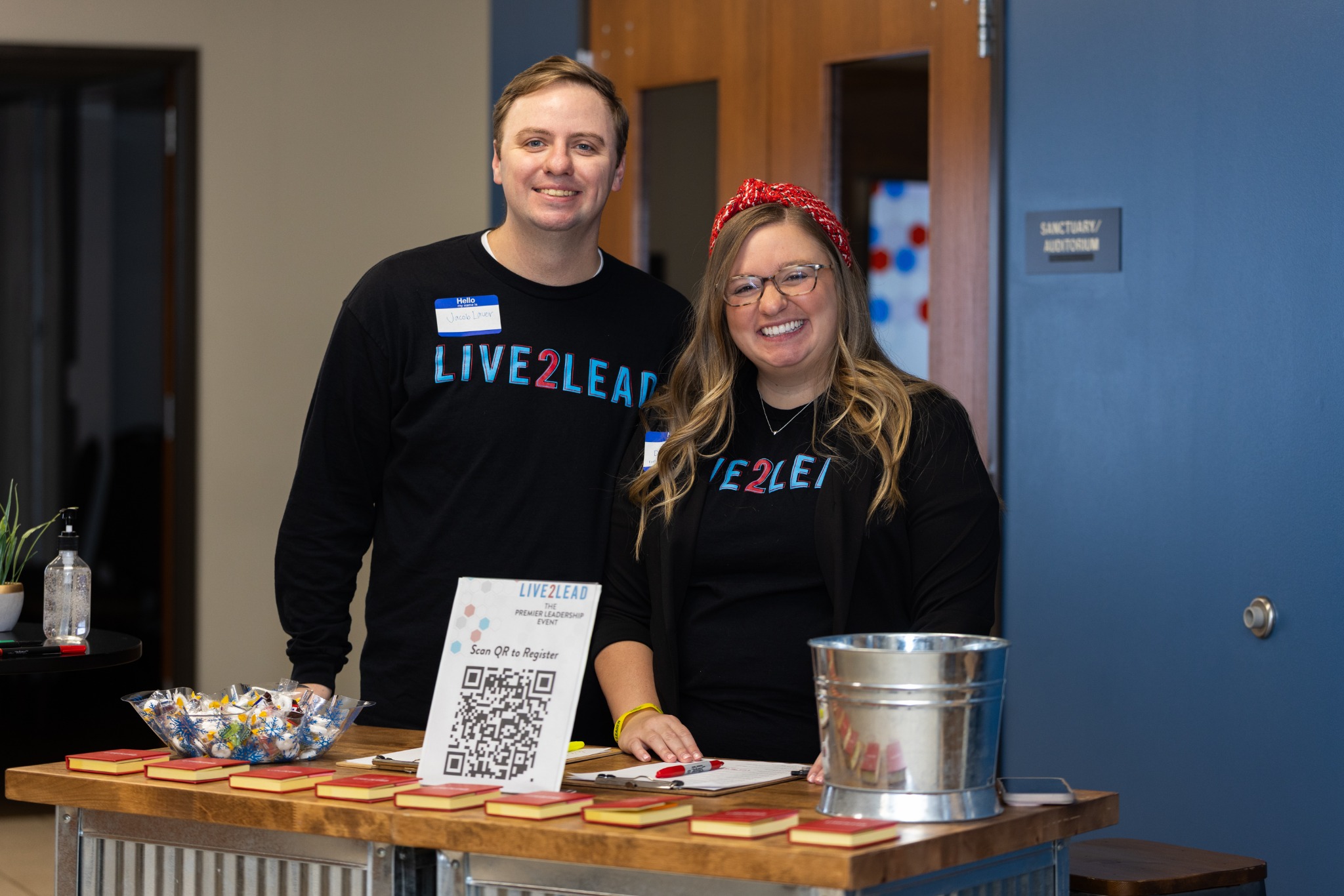Two members of the Live2Lead welcome team at the registration table