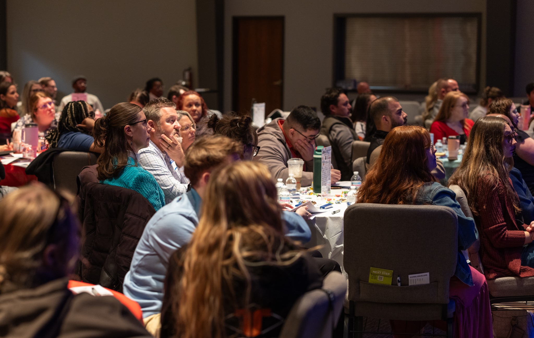 Attendees listening together at tables during a previous Live2Lead event