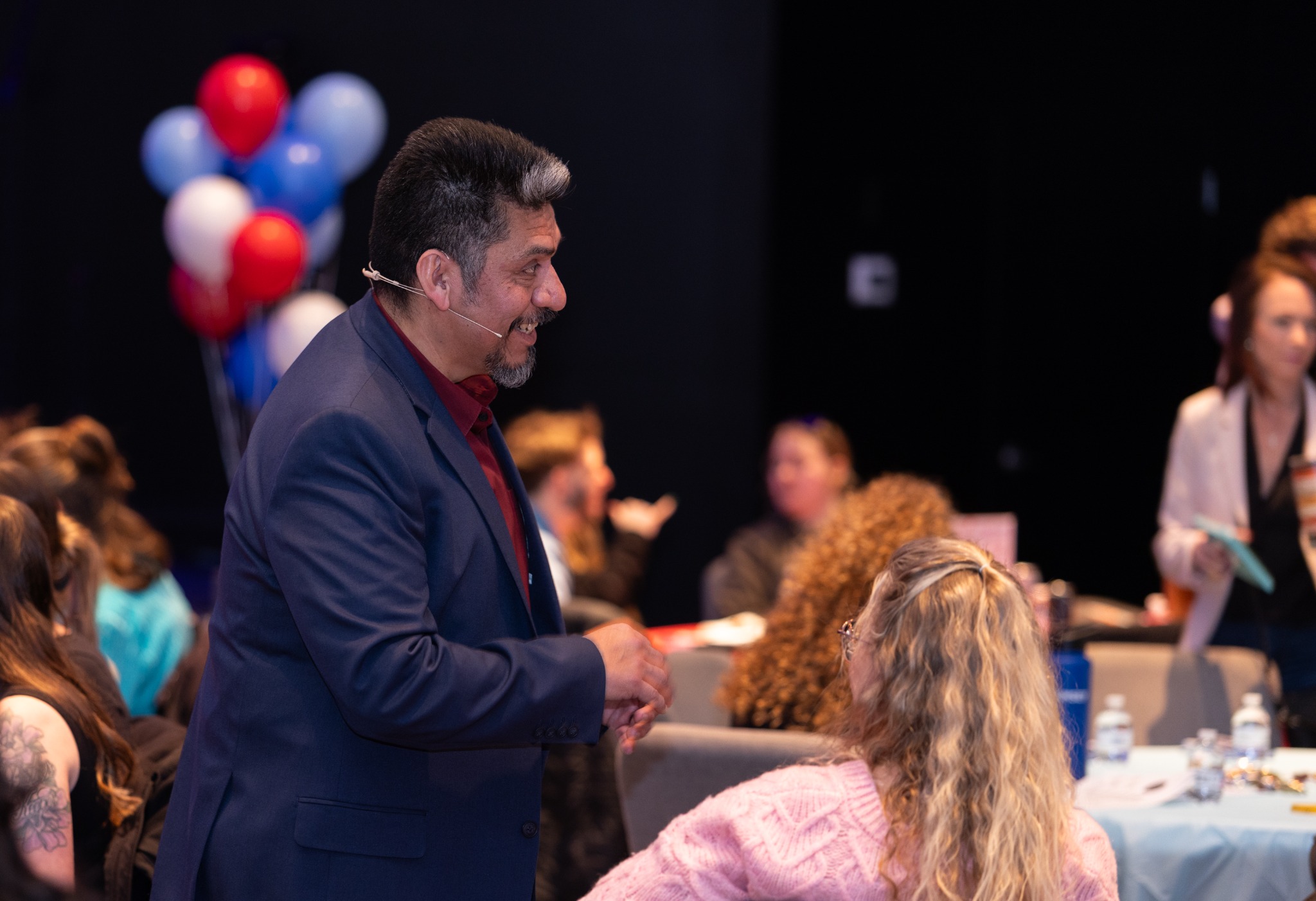 Heber Mena talking with attendees among the event tables