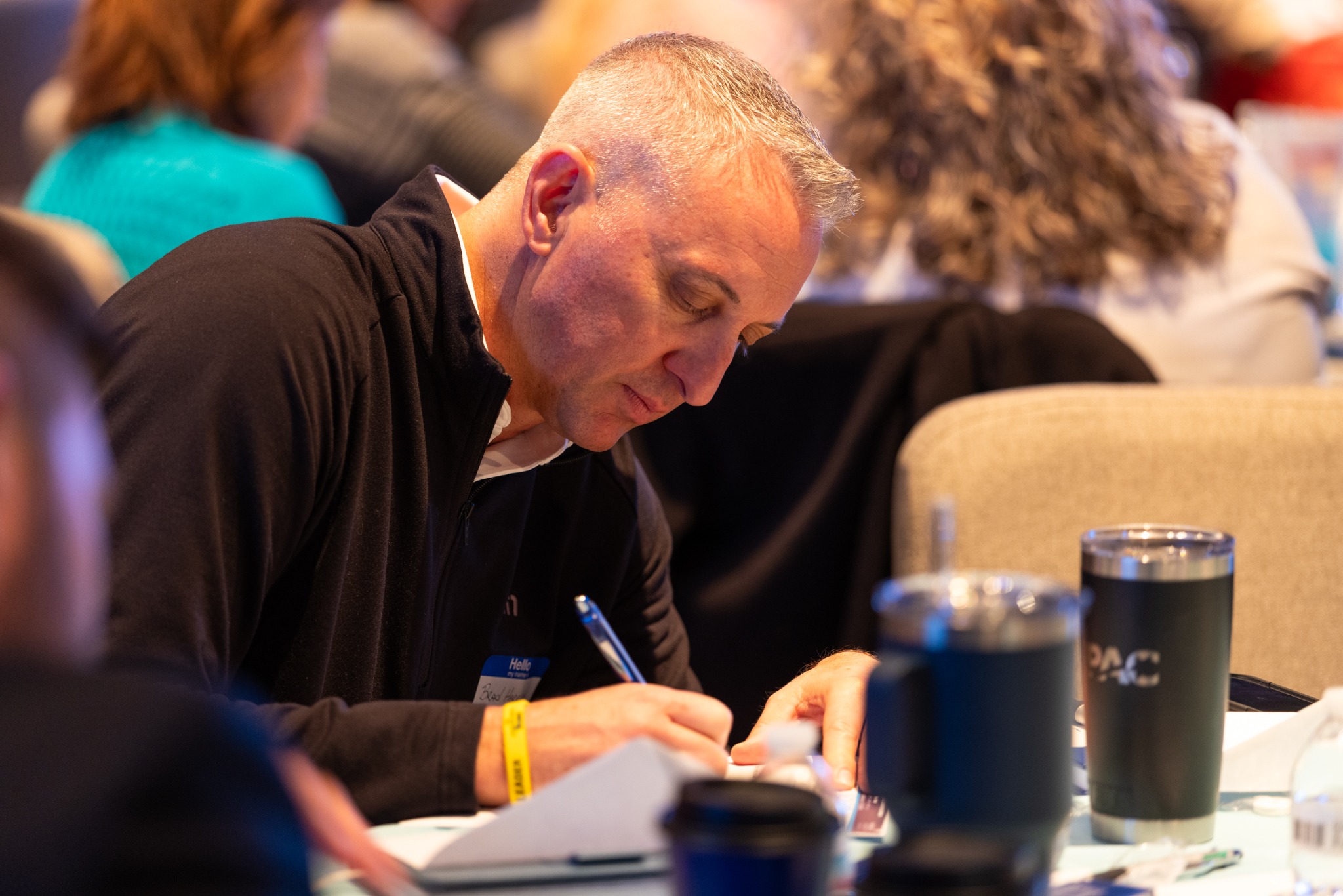 An attendee writing notes during the leadership event